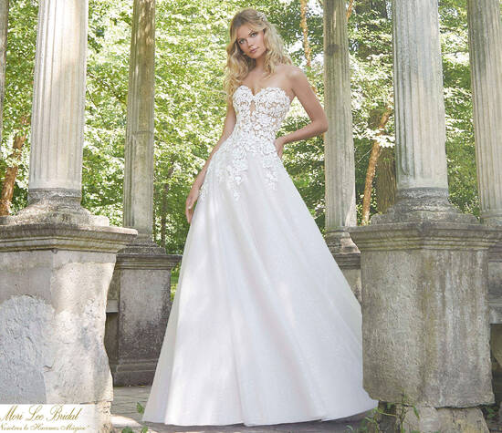 Estilo OZIX
Pierette Wedding Dress
Pearlized Beading on Three-Dimensional, Embroidered Lace Appliqués on an English Net Ballgown Over Glitter Net.